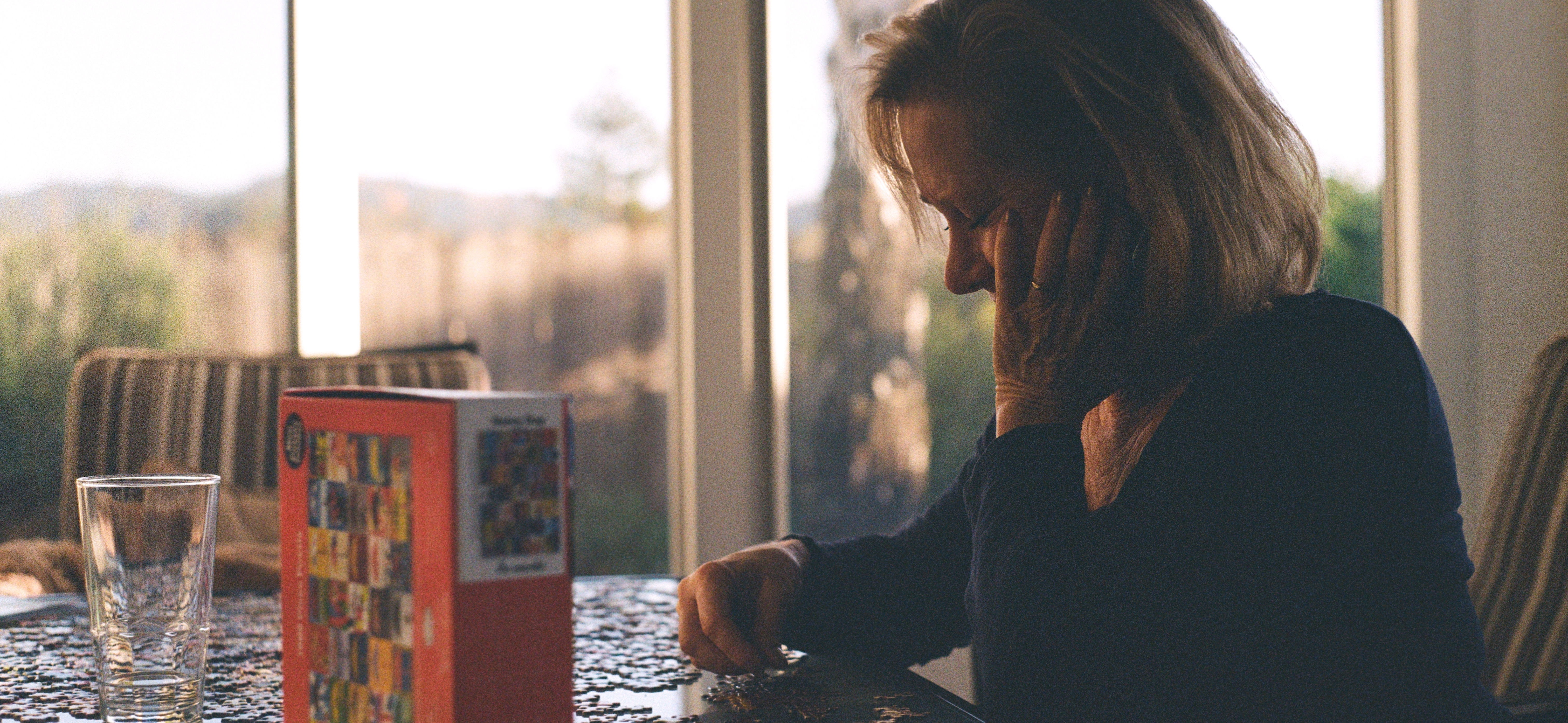 Mom doing a puzzle in golden hour light